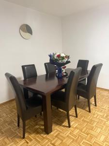 a dining room table with black chairs and a vase of flowers at Salt City Apartments in Sepetari