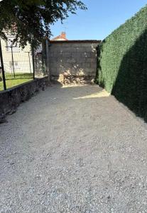 a brick wall with a hedge next to a driveway at Cécile Foissy in Pogny