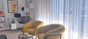 a living room with two chairs and a table and a window at Apartman Romansa in Fojnica +3 photos