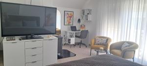 a living room with a large television on a white dresser at Apartman Romansa in Fojnica