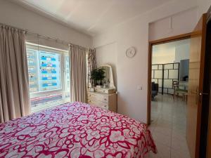 a bedroom with a bed and a large window at Atlantic Romantic Caparica Flat in Costa da Caparica