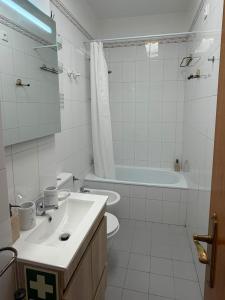 a bathroom with a sink and a toilet and a tub at Atlantic Romantic Caparica Flat in Costa da Caparica