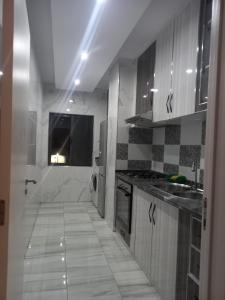 a kitchen with a white tile floor and cabinets at Sunset Serenity Flat in Praia