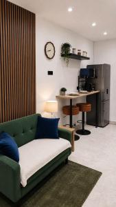a living room with a green couch and a kitchen at The Studio Spot in Caerphilly