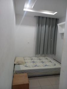 a small bed in a room with a window at Sunset Serenity Flat in Praia