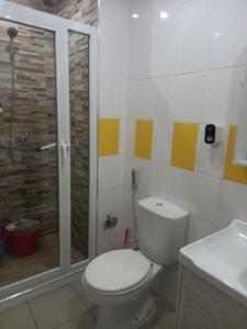 a bathroom with a toilet and a glass shower at Sunset Serenity Flat in Praia