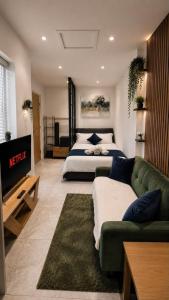 a bedroom with a bed and a green couch at The Studio Spot in Caerphilly