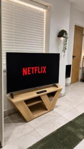 a television on a wooden stand in a living room at The Studio Spot in Caerphilly