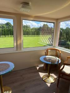 a room with two tables and two windows at Kalna Raskumu Apartamenti in Vecpiebalga +41 photos