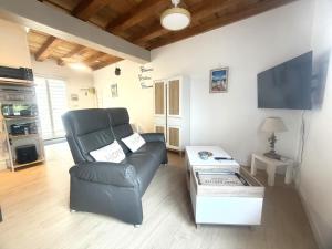 a living room with a chair and a table at Le Ptit Roc, cocon cosy in Chailles