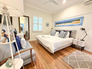 a bedroom with a bed and a ladder at Barbara's Byron Bay in Byron Bay