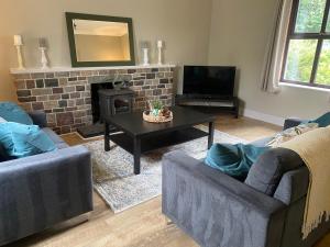 a living room with two couches and a fireplace at Foxs Farmhouse in Ballinrobe