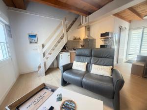 a living room with a couch and a table at Le Ptit Roc, cocon cosy in Chailles