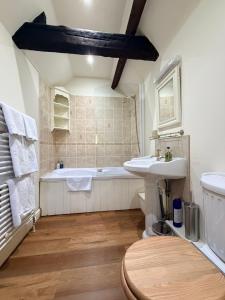 a bathroom with a sink and a bath tub at Braunston Manor Cottage in Braunston