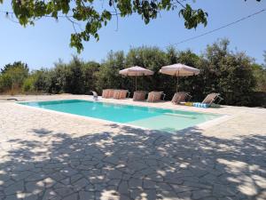 a swimming pool with chairs and umbrellas at La Macchia in Botrugno