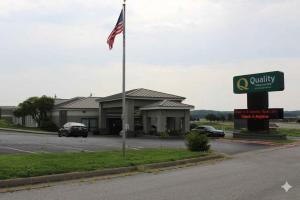 a flag in front of a building with a parking lot at Quality Inn & Suites Moline Airport in Moline