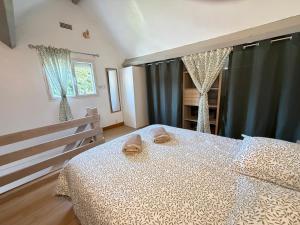 a bedroom with a bed with two shoes on it at Le Ptit Roc, cocon cosy in Chailles