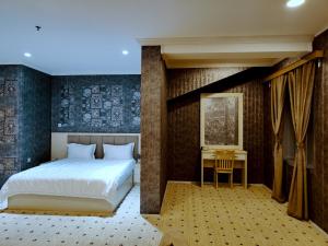 a bedroom with a large bed and a desk at Basra Touristic Hotel in Al Başrah