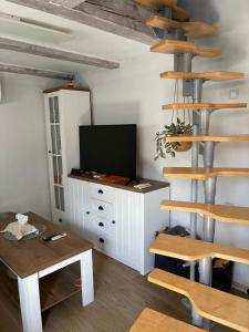 a living room with a television and wooden shelves at Domek se zahrádkou in Zbečno +13 photos