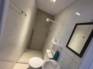 a white bathroom with a toilet and a mirror at Flats 1778 N01 Orla de Petrolina in Petrolina +11 photos