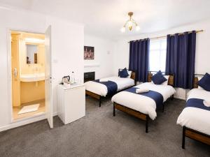 a room with four beds and a mirror at High Trees Guest House Gatwick in Horley +110 photos