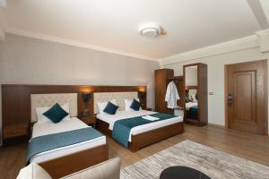 a hotel room with two beds and a chair at Alegria Hotel in Prizren +43 photos