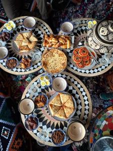 a table topped with plates of food and pies at Auberge de Chez Momo in Asilah +14 photos
