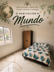 a bedroom with a bed with a sign on the wall at Pachamama House in Bucaramanga