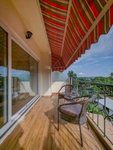 a balcony with two chairs and an umbrella at Hotel Le Amritam in Dehradun