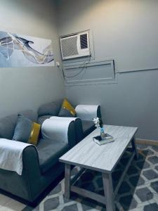 a living room with a couch and a table at غرفة وصالة في موقع مميز ترخيص ضيافة خاصة in Khamis Mushayt