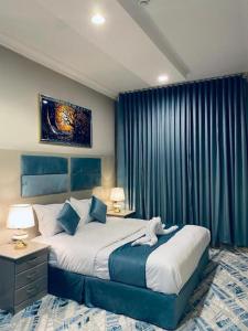 a bedroom with a large bed with blue curtains at غرفة وصالة في موقع مميز ترخيص ضيافة خاصة in Khamis Mushayt