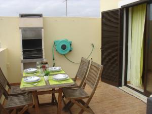 uma mesa e cadeiras num quarto com um aperitivo em Apartamento Sol e Mar 2 em Monte Gordo