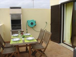 una mesa y sillas en una habitación con aperitivo en Apartamento Sol e Mar 2, en Monte Gordo