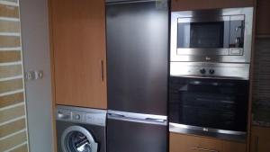 una cucina con forno a microonde, lavatrice e asciugatrice di Apartamento Sol e Mar 1 a Monte Gordo Altre 14 foto