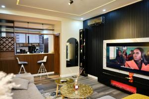 a living room with a couch and a flat screen tv at Revkon Apartments in Abuja