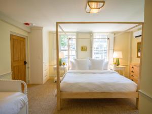 a bedroom with a large white bed with a wooden frame at Sawyer House in Nantucket