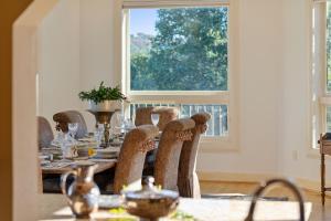 a dining room with a table with chairs and a window at Bella Villa Messina in Healdsburg