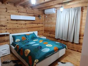 a bedroom with a bed in a log cabin at Villa NEOM, Sarajevo in Vogošća