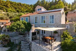 a stone house with a patio and a table at Stone house Mia in Čara