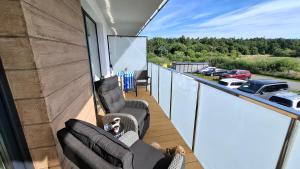a balcony with chairs and a view of a parking lot at Golden Sun Apartment Grzybowo in Grzybowo