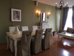 a dining room with a white table and chairs at La Perle Apartment in Utrecht