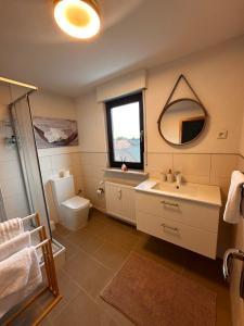 a bathroom with a sink and a toilet and a mirror at Ferienwohnung mit Schminktisch 2OG in Gräfenhainichen +17 photos