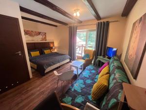 a bedroom with a bed and a couch in a room at Willa Plejady in Karpacz