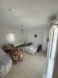 a white room with two beds and a table at White House with Sea View in Ambelas +18 photos