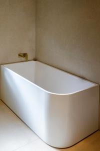 a white bath tub sitting in a room at Simple Style Among the Gums 