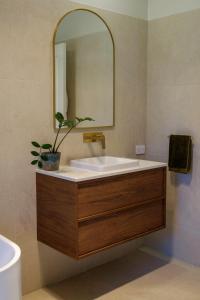 a bathroom with a sink and a mirror at Simple Style Among the Gums 