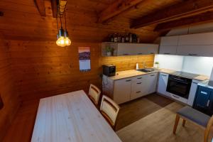 a kitchen with a table and chairs in a cabin at Raj pod vrhom in Poljane nad Škofjo Loko +12 photos