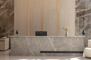 a reception desk in a lobby with a vase of flowers at Alegria Hotel in Prizren