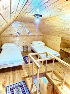 a room with two beds in a wooden cabin at Domeniul Ursului in Vadu Izei