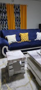 a living room with a blue couch with yellow pillows at Gee homestay Kakamega in Kakamega